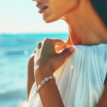 Load image into Gallery viewer, A close-up image of a woman's wrist wearing a silver bracelet with a cascading pattern of zirconia stones, set against a beach backdrop.
