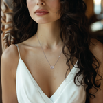 Load image into Gallery viewer, A woman wearing a white dress and a silver necklace with an emerald-cut lab-grown stone pendant.