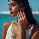 Load image into Gallery viewer, A person wearing a silver and aqua blue ring on their finger, with a blurred background.