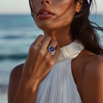 Load image into Gallery viewer, A woman wearing a white dress and a silver ring with a vibrant blue stone on her finger.