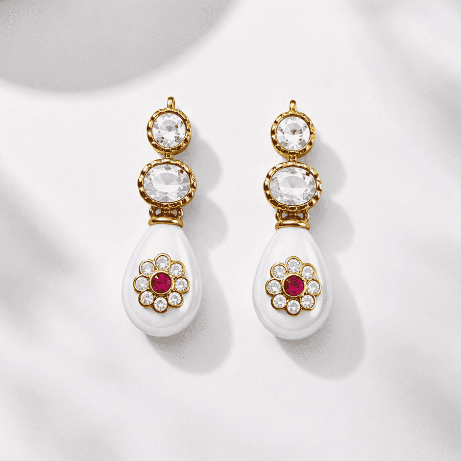Pair of earrings with gold and white design on a light background