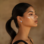 A woman with her hair in a ponytail wearing the Radiance Silver Studs earrings.