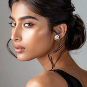 A close-up image of a woman's face with silver stud earrings in her ears.