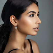 A close-up image of a woman wearing dangling square silver earrings.